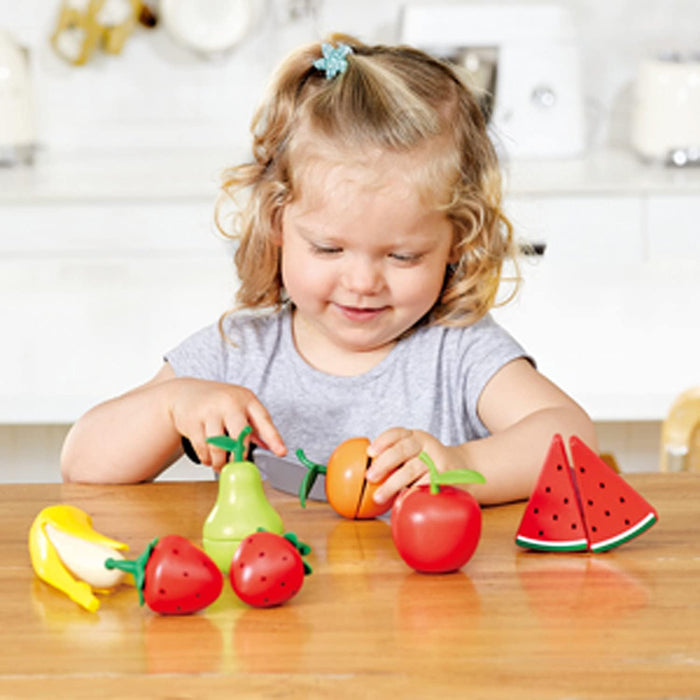 Child playing with fruit Playset on a wood table