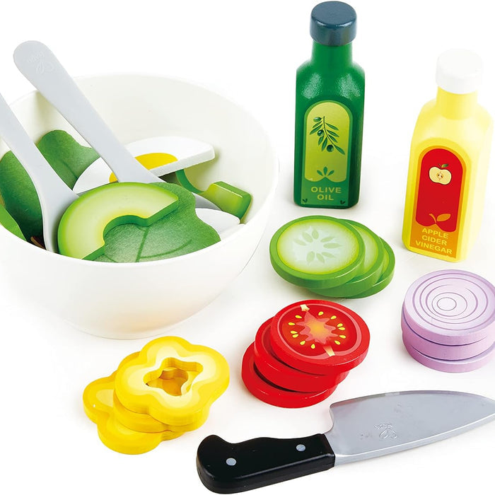 Colorful toy kitchen set with vegetables, a knife, and bottles on a white background