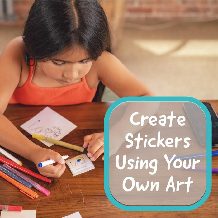Child creating stickers using their own art with markers and paper on a table.