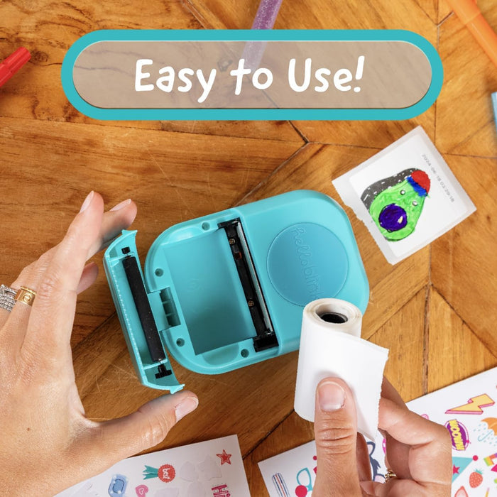Turquoise printer being used on a wooden surface with colorful printed materials.