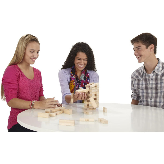 Three people playing Jenga on a white table against a white background