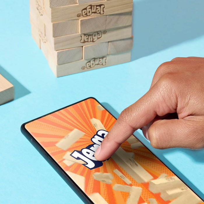 Hand playing with Jenga game pieces on a smartphone App on a blue surface