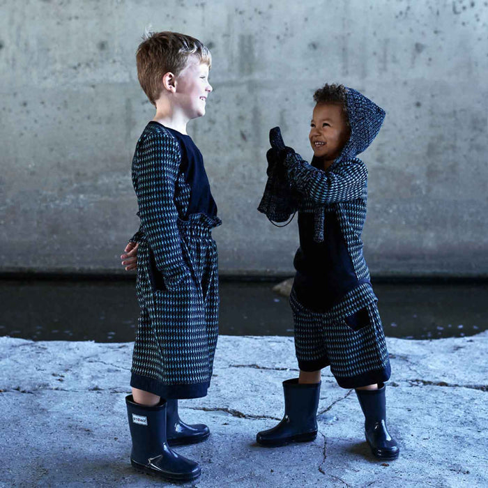hild wearing black and blue knitted gloves outdoors in winter