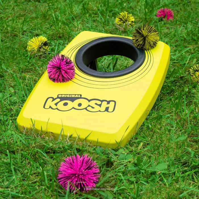 Koosh Kornhole game on a green lawn.