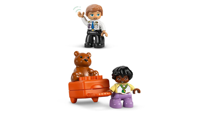 LEGO figures of a police officer, a child, and a teddy bear on an orange toy car against a white background