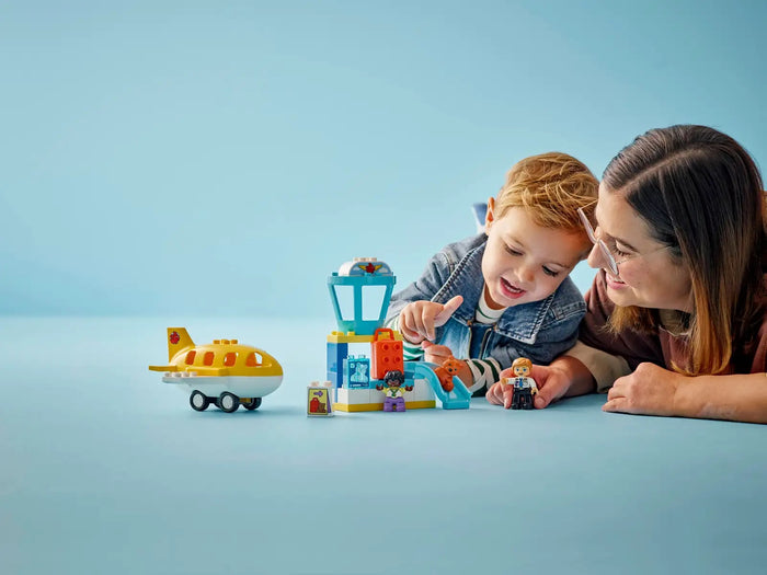 Child and adult playing with toy building blocks on a blue background