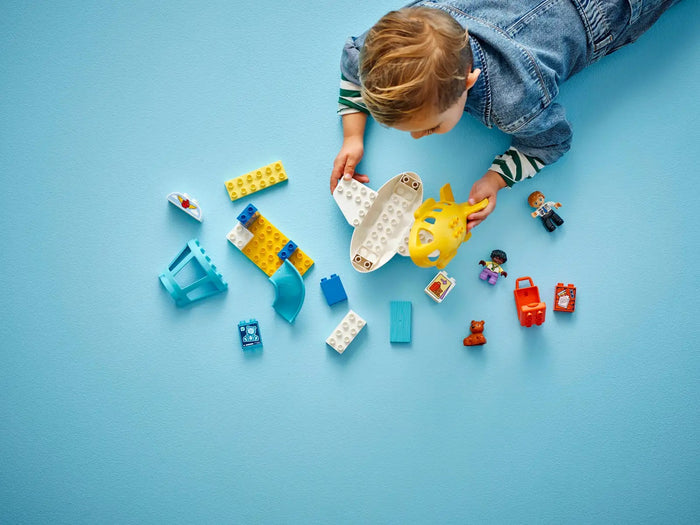 Child playing with colorful building blocks on a blue background