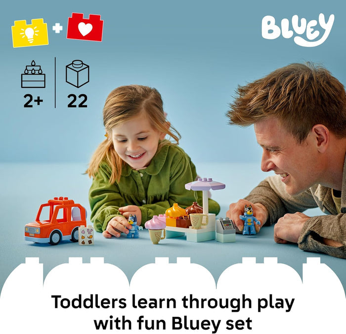 Man and child playing with toys on a blue background, featuring the Bluey brand.