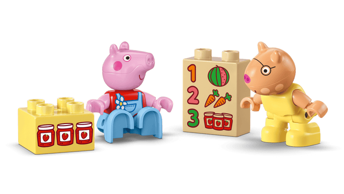 Two toy figures, one resembling a pig and the other a bear, with educational blocks on a green background.