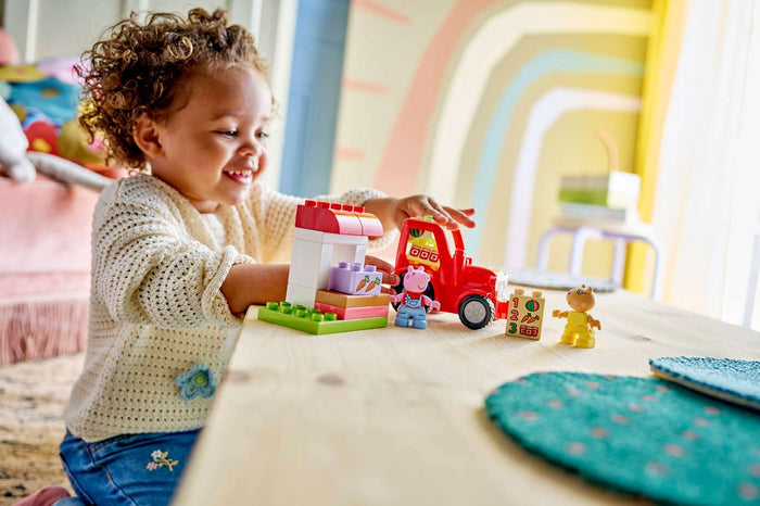 Child playing with toy truck and figures on a table with a colorful background