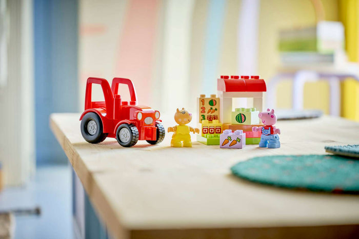 Toy red tractor and colorful building blocks on a table with a blurred background
