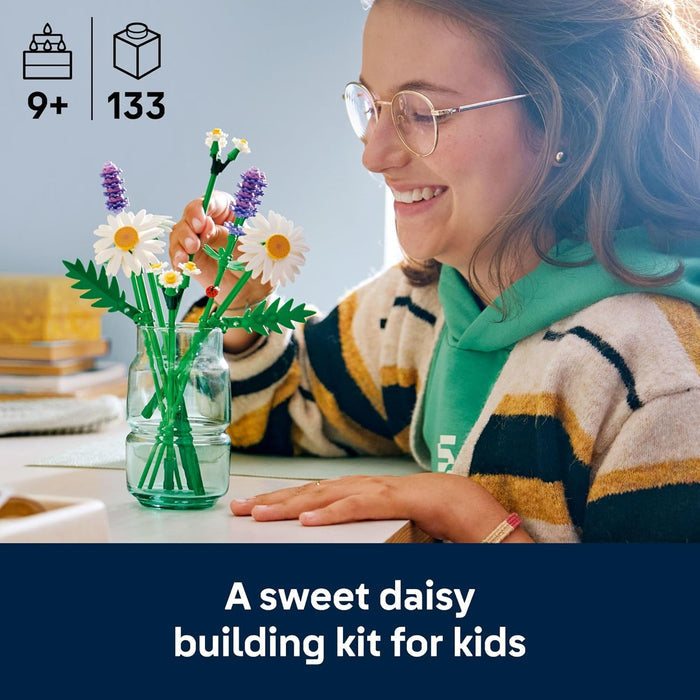 Person building a sweet daisy flower set with a clear vase, surrounded by building blocks and a blue background.