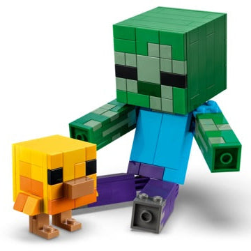 A Minecraft-style toy figure of a green zombie-like blocky character with a blue torso and purple legs, posed next to a small yellow-orange bird figure on a clean white background.