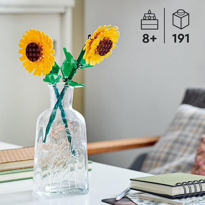 Toy sunflowers in a clear vase on a table with age recommendation and piece count icons.