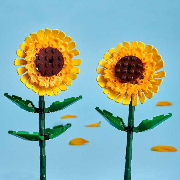 Two sunflower-shaped objects made from interlocking bricks on a blue background