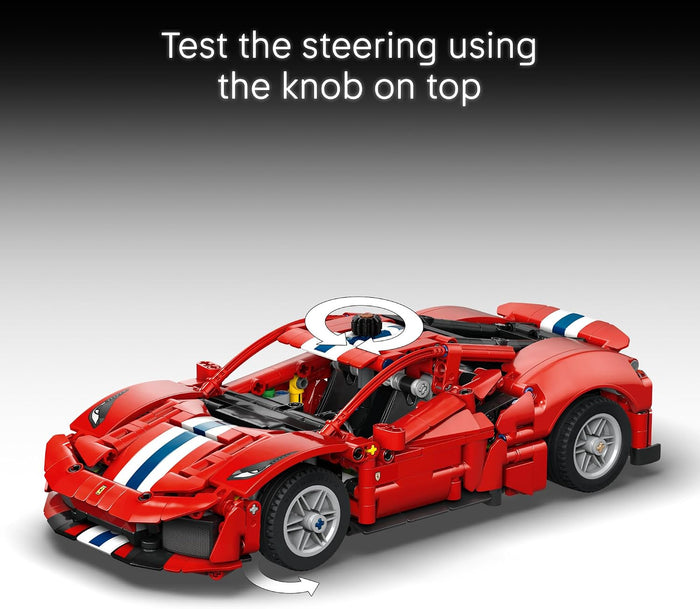 A red building-block toy sports car with white and blue racing stripes, shown on a gray gradient background with instructional text reading 'Test the steering using the knob on top' and steering arrows indicating movement.