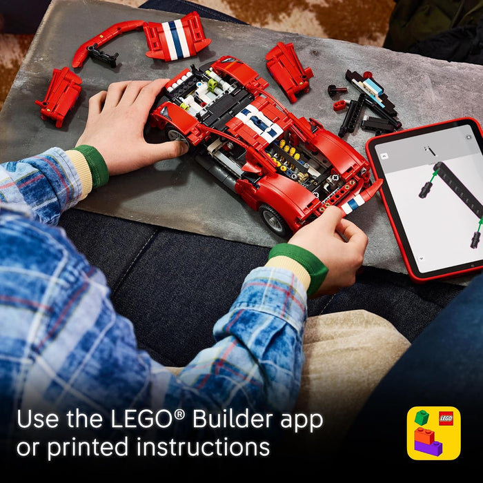 A child's hands building a red LEGO Technic car on a gray work surface, with the car disassembled into parts around it and a tablet showing the LEGO Builder app. Text at the bottom says 'Use the LEGO Builder app or printed instructions' and a LEGO app icon appears in the lower right.