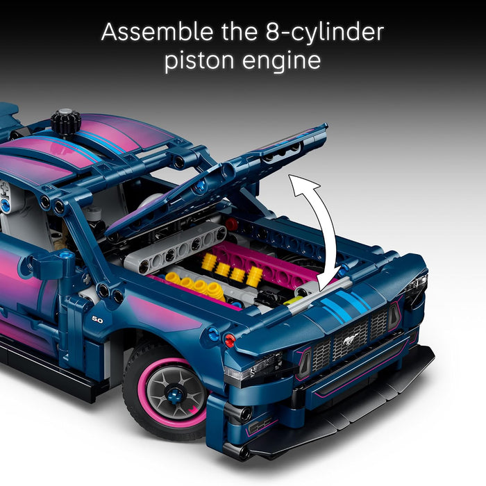 Blue toy car with open engine bay showing 8-cylinder piston engine assembly, on a gray background.