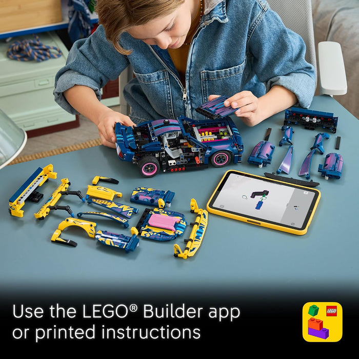 A child sits at a table assembling a blue and purple LEGO building set with a tablet showing the LEGO Builder app, surrounded by disassembled toy parts and printed instruction text at the bottom.