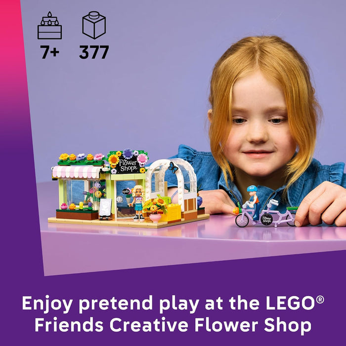 Child playing with a LEGO Friends Creative Flower Shop set on a purple background