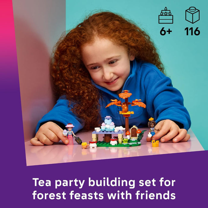 Child playing with a tea party building set on a table, with a colorful background.