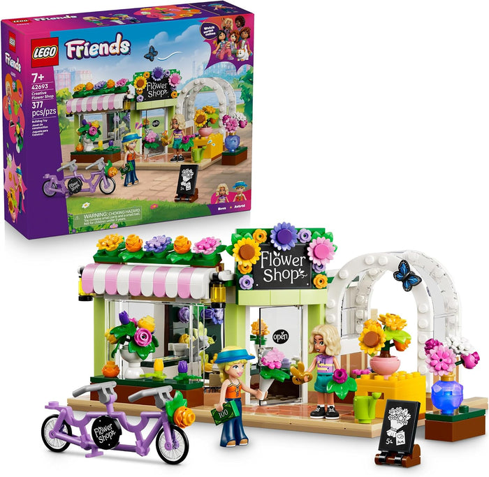 LEGO Friends Flower Shop building set shown with its retail box on a white background. The set includes a small flower shop building with a pink-and-white awning, colorful flower decorations, a white arched entrance, a purple tandem bicycle, a female minifigure, and small accessories.