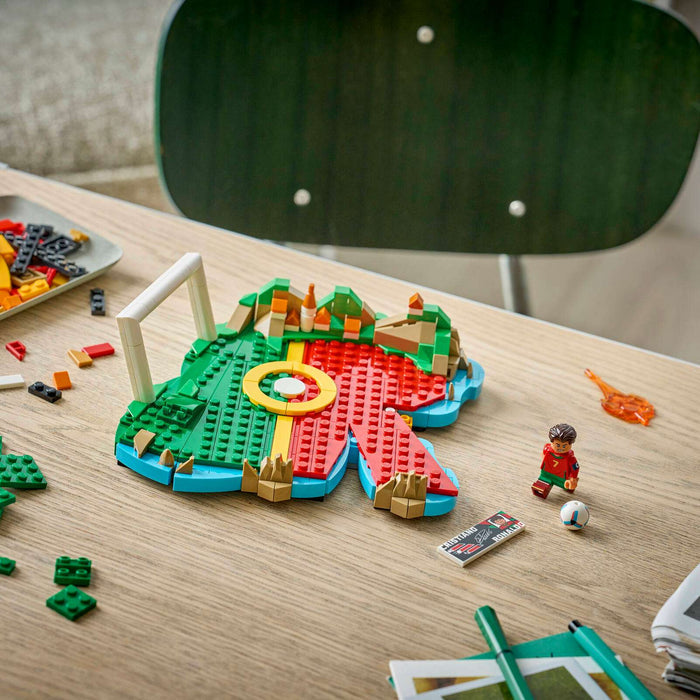 Colorful building blocks on a wooden table with scattered pieces and a chair in the background.