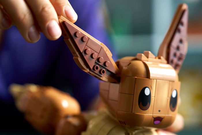 Close-up of a toy figure being assembled with a focus on the headpiece.