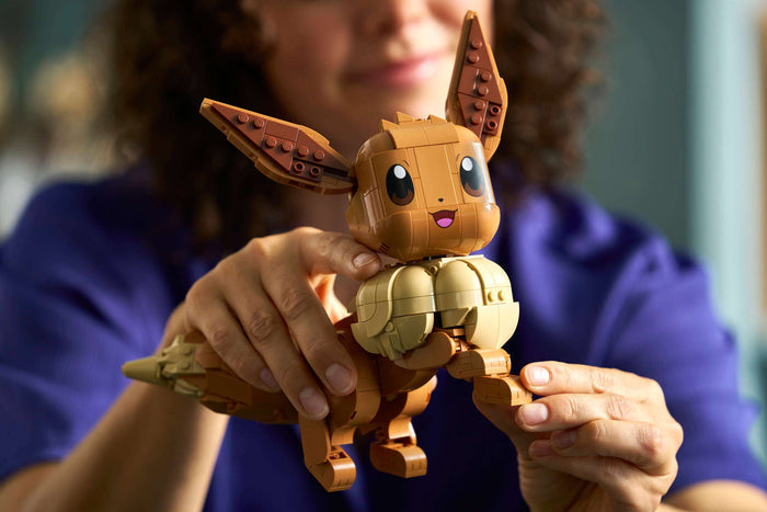 Person holding a LEGO Eevee figure in front of a blurred background