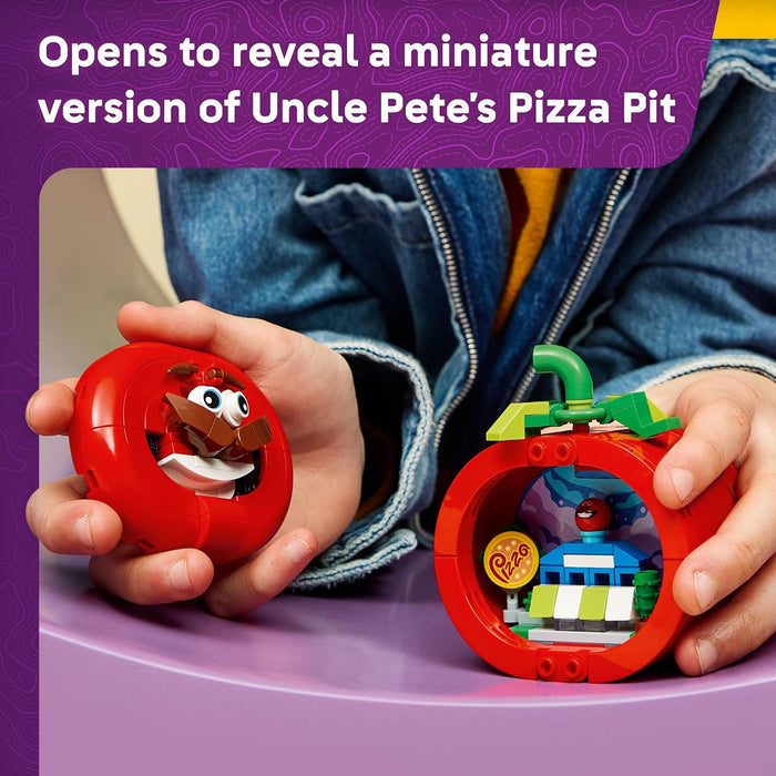 Child holding a red toy with a miniature pizza pit inside, against a purple background.