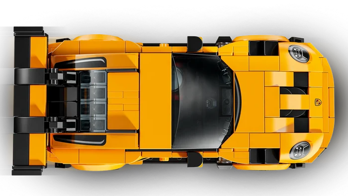 Top-down view of a yellow sports car model made from interlocking bricks on a white background
