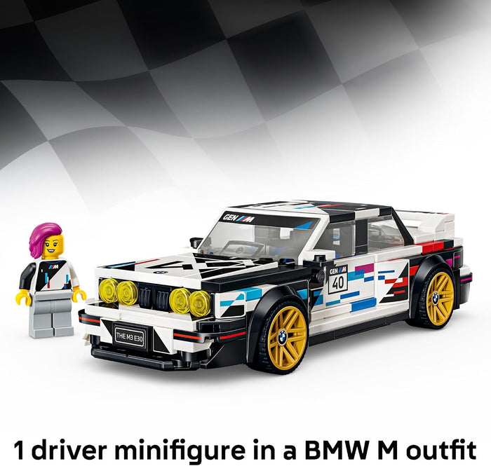 A LEGO-style racing car model in a white, black, blue, and red BMW M-inspired livery with gold wheels, shown beside a small driver minifigure wearing a white and black racing suit and magenta hair. The background is a black-and-white checkered flag graphic on a white studio-style field, with text at the bottom reading '1 driver minifigure in a BMW M outfit'.