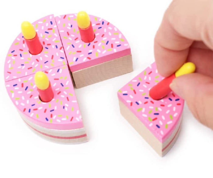 Wooden cake in four sections with pink icing colorful sprinkles and four removable  pretend candles