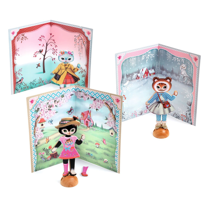 Three Little Wardrobe Collage dress up cats, one pink, one yellow and one blue outfit, with scenic backdrops on a white background