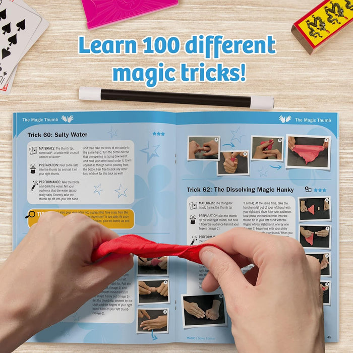 Instruction manual on a wooden table top with text 'Learn 100 different magic tricks!'