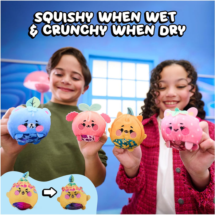 Two children holding four colorful squishy plush toys in front of a blue studio backdrop, with text reading 'SQUISHY WHEN WET & CRUNCHY WHEN DRY' and a small inset showing a yellow toy transforming.