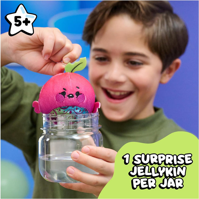 Child holding a pink jellykin toy inside a clear jar with text about a surprise jellykin per jar.