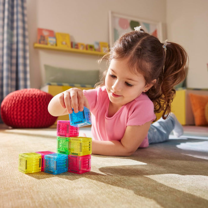 Child stacking Magna Tile Cubes on the floor in a bedroom
