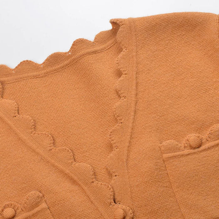 Close-up of a brown textured fabric with scalloped edges on a light gray background