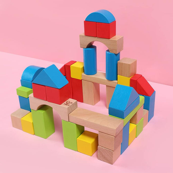Stacked Maple Building Blocks on a pink background.