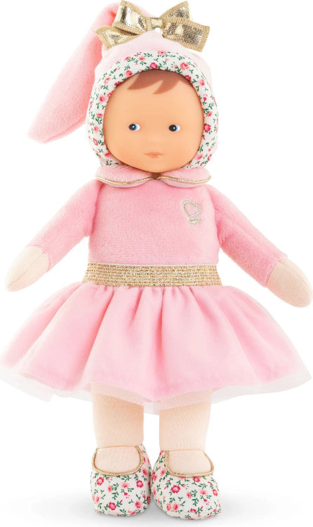 Doll in a pink outfit with a bow on a white background