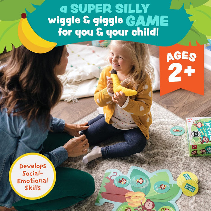 Woman and child playing with a toy banana, sitting on the floor with game cards around them.
