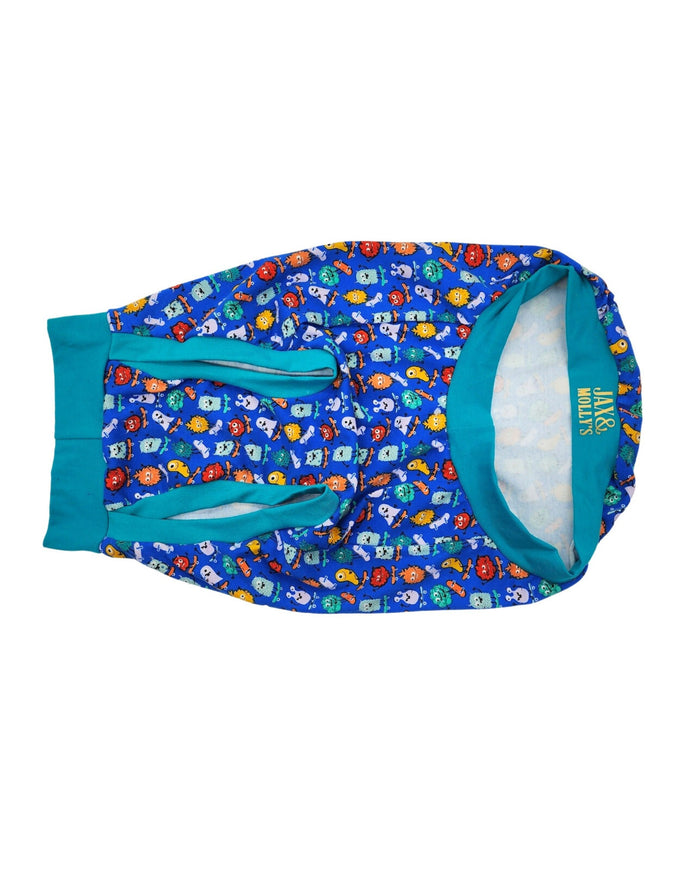 Underbelly view of Jax & Molly's dog pajamas featuring an adorable print of colorful monster on skateboards complimented by a jade colored trim.