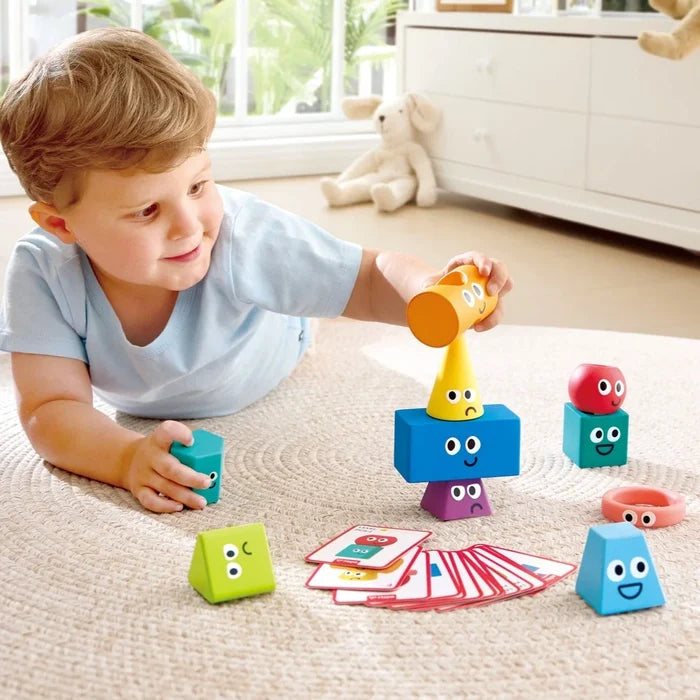 Child playing with colorful geometric shape toys on a carpeted floor.