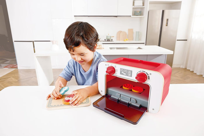 Child playing with a toy oven in a kitchen setting