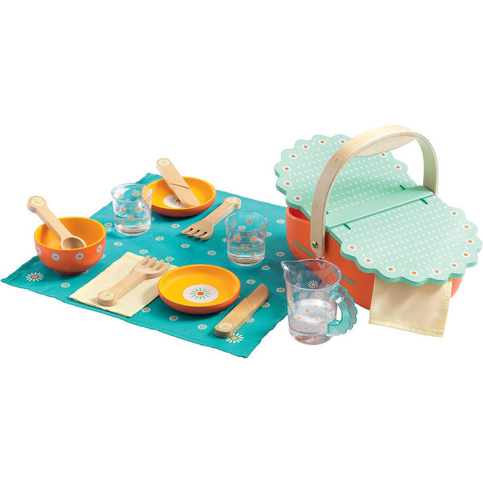 Children's play picnic set with colorful dishes, basket, and tablecloth on a white background