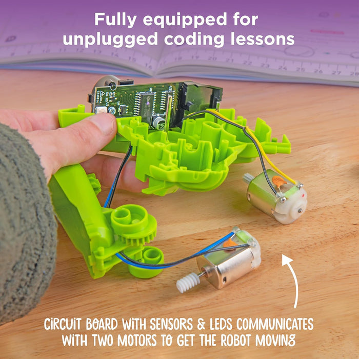 Green robot kit with circuit board and motors on a wooden surface, text about unplugged coding lessons.