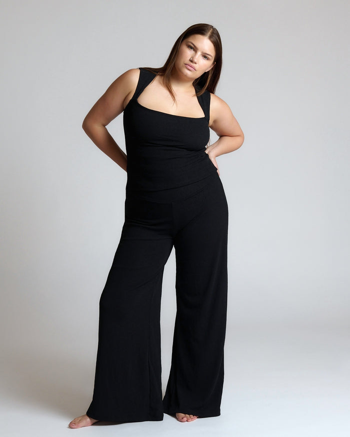 Woman wearing a black outfit on a plain background