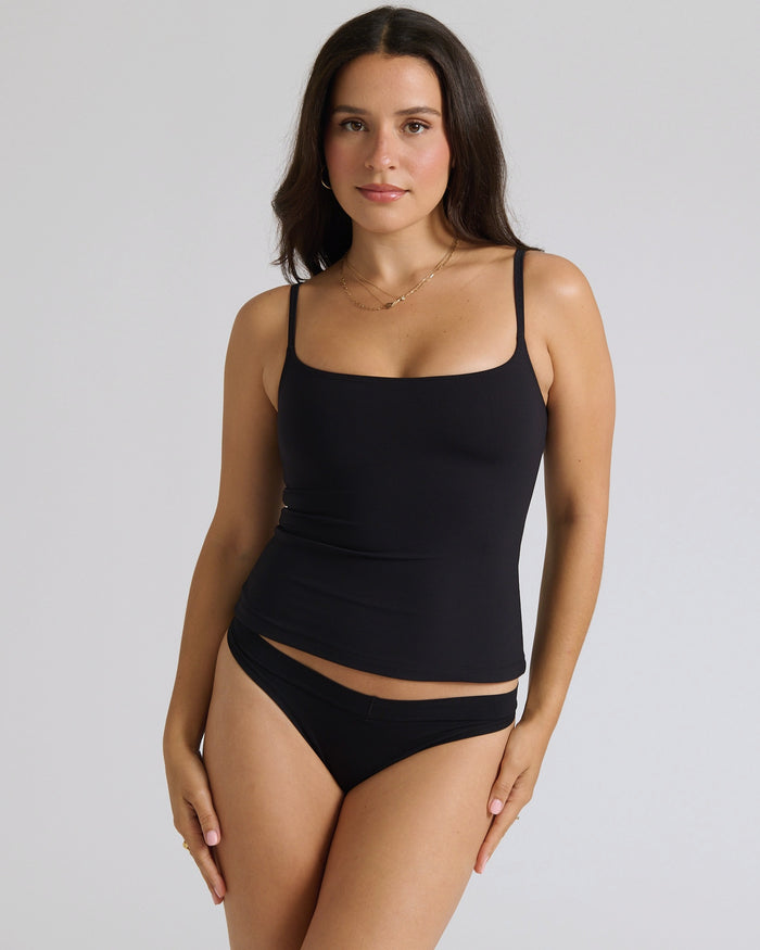 Woman wearing a cami top against a plain background