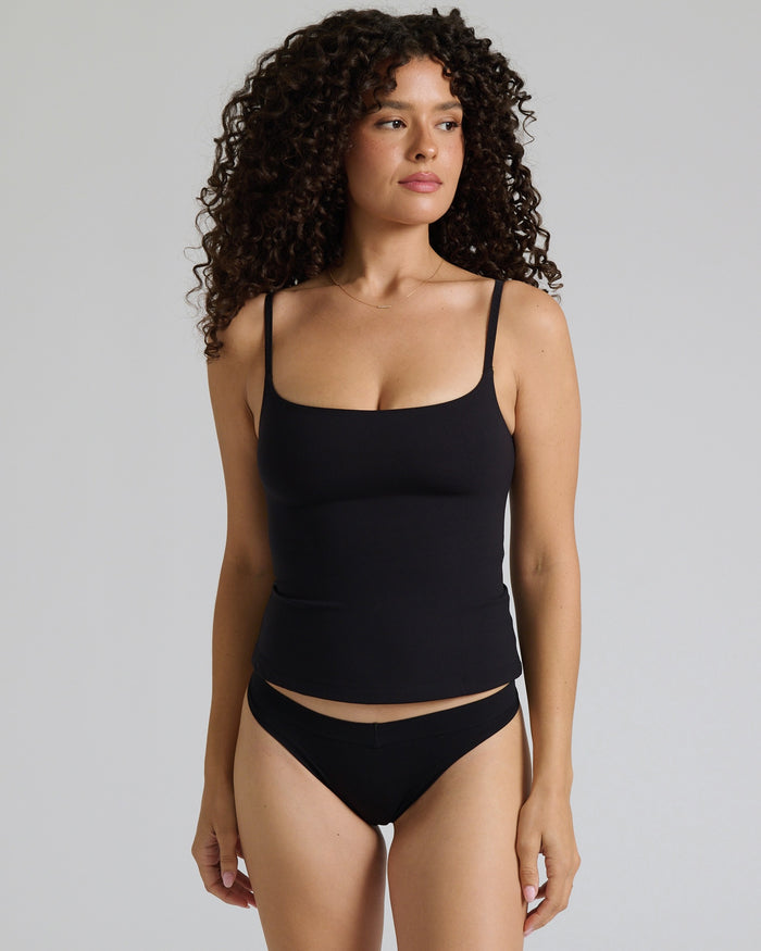 Woman wearing a cami top against a plain background